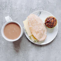 a cup of coffee and a muffin on a plate