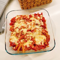 a glass dish with pasta and cheese in it