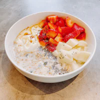 a bowl of oatmeal with strawberries and chia seeds