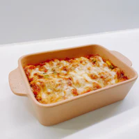 a dish with lasagna in it sitting on a table
