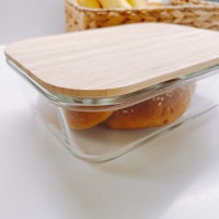 a glass container with a wooden lid on a table