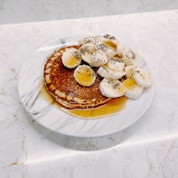 a plate topped with pancakes and bananas