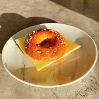 a bagel with cheese and sesame on a plate
