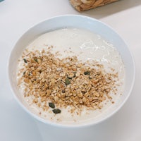 a bowl of yogurt with granola and seeds