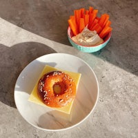 a plate with a donut and carrots on it