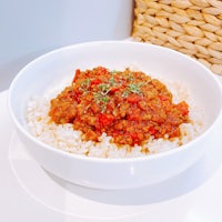 a white bowl with rice and meat in it