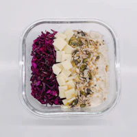a bowl with red cabbage, nuts and seeds