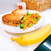 a plate of food with a sandwich and a banana on it