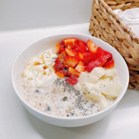 a bowl of oatmeal with strawberries and chia seeds