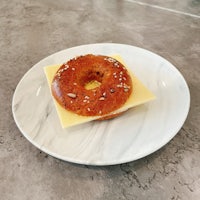 a bagel with cheese and sesame on a plate