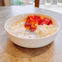 a bowl filled with fruit and yogurt on a table