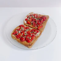 two slices of toast with strawberries and basil on a plate