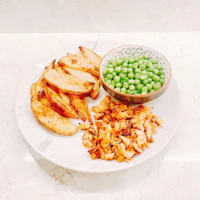 a white plate with peas and potatoes on it