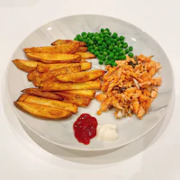 a plate with fries, peas and ketchup